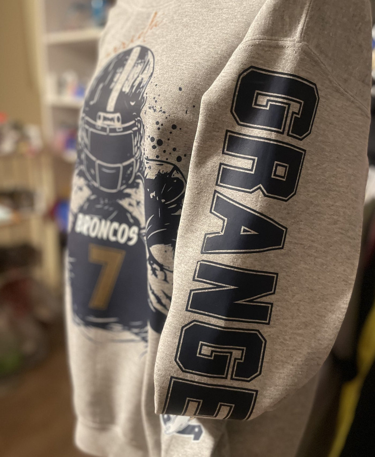Close-up of embroidered lettering down a crewneck sleeve