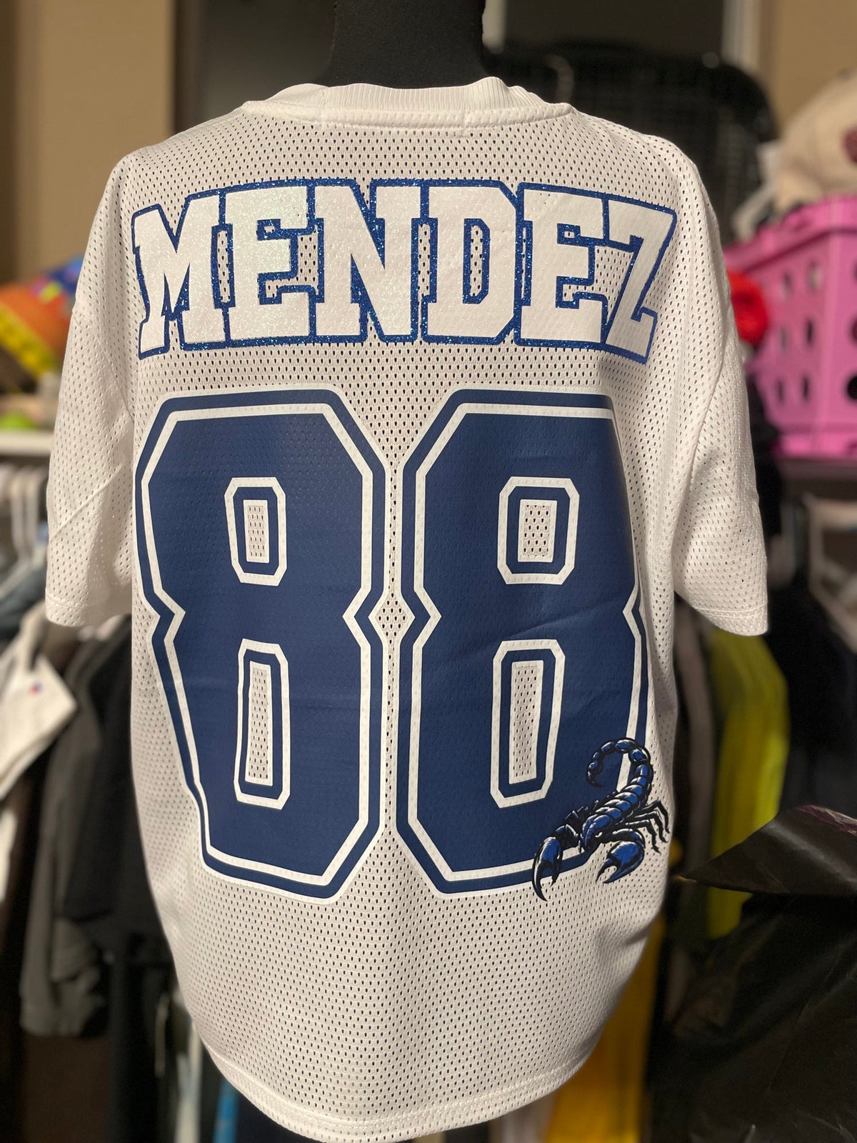 Back of a white custom mesh football jersey with a name and number in blue